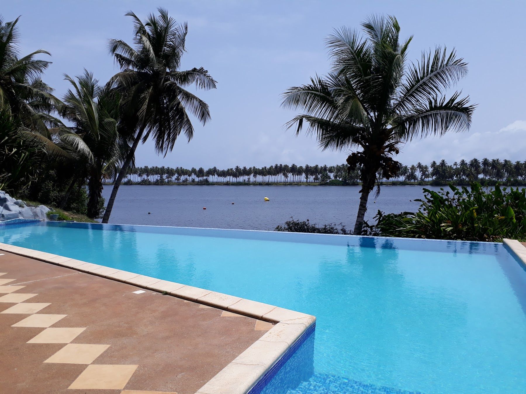 Piscine et terrasse carrelée, la lagune en arrière-plan
